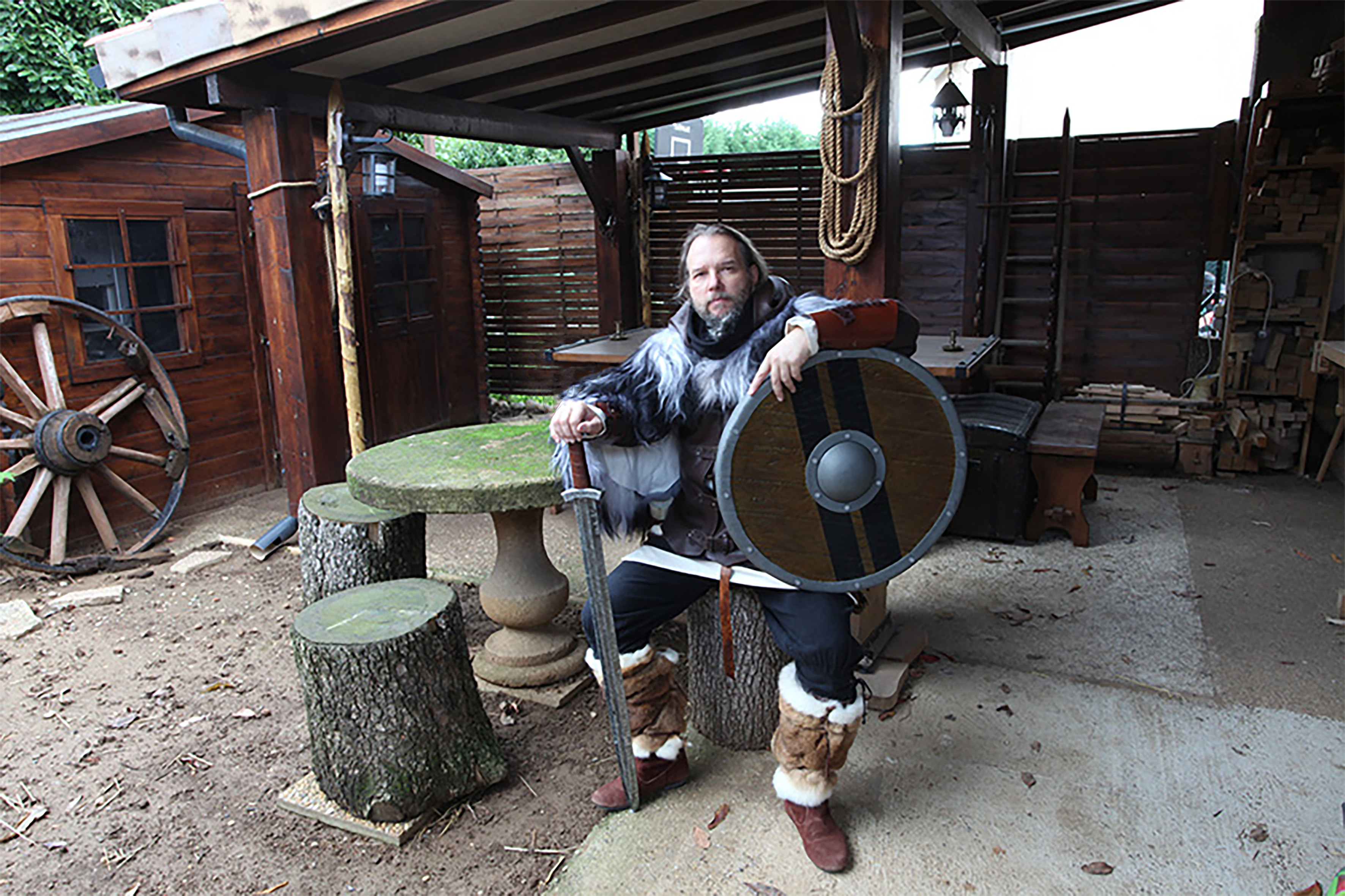 Conrad, artisan médiéval, à l'Auberge Médiévale Seigneuriale avec son épée et son bouclier